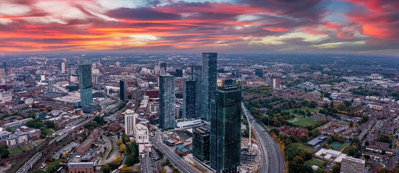 Aerial view of the Manchester city centre skyline at sunset, showing the Deansgate Square high-rise cluster